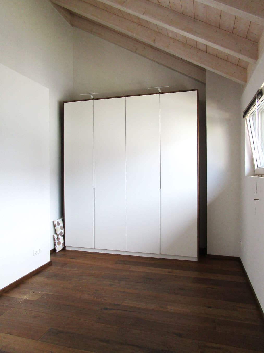 Weißer Einbauschrank unter der Dachschräge