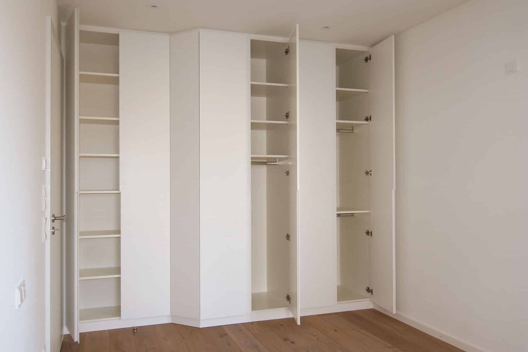 Weißer Einbauschrank im Schlafzimmer mit geöffneten Türen