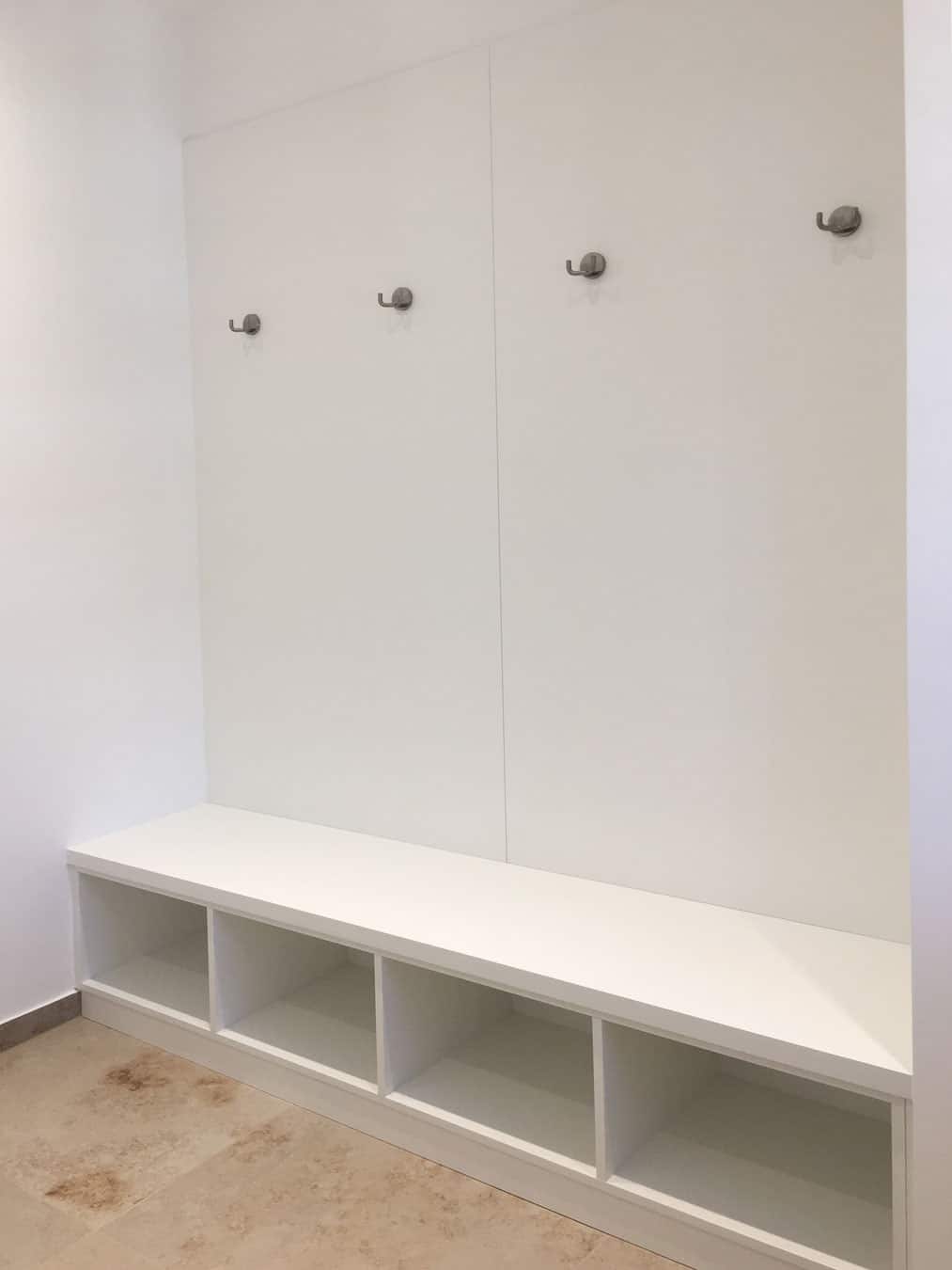 Weiße Einbaugarderobe mit Sitzbank und Fächern