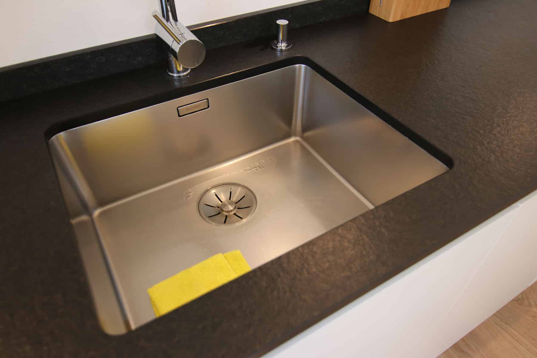 Edelstahl-Spülbecken in dunkler Arbeitsplatte