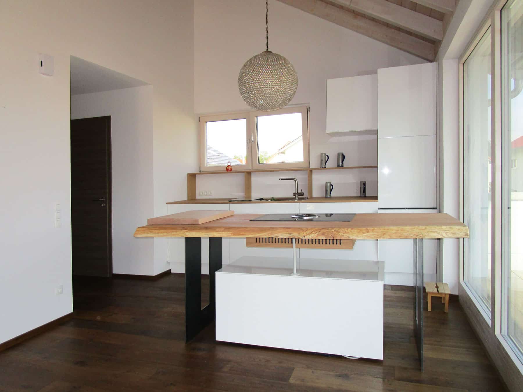 Freistehende Küche mit Holztisch unter der Dachschräge