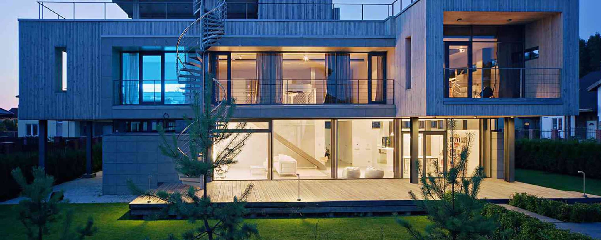 Moderne Villa mit großzügiger Verglasung am Abend