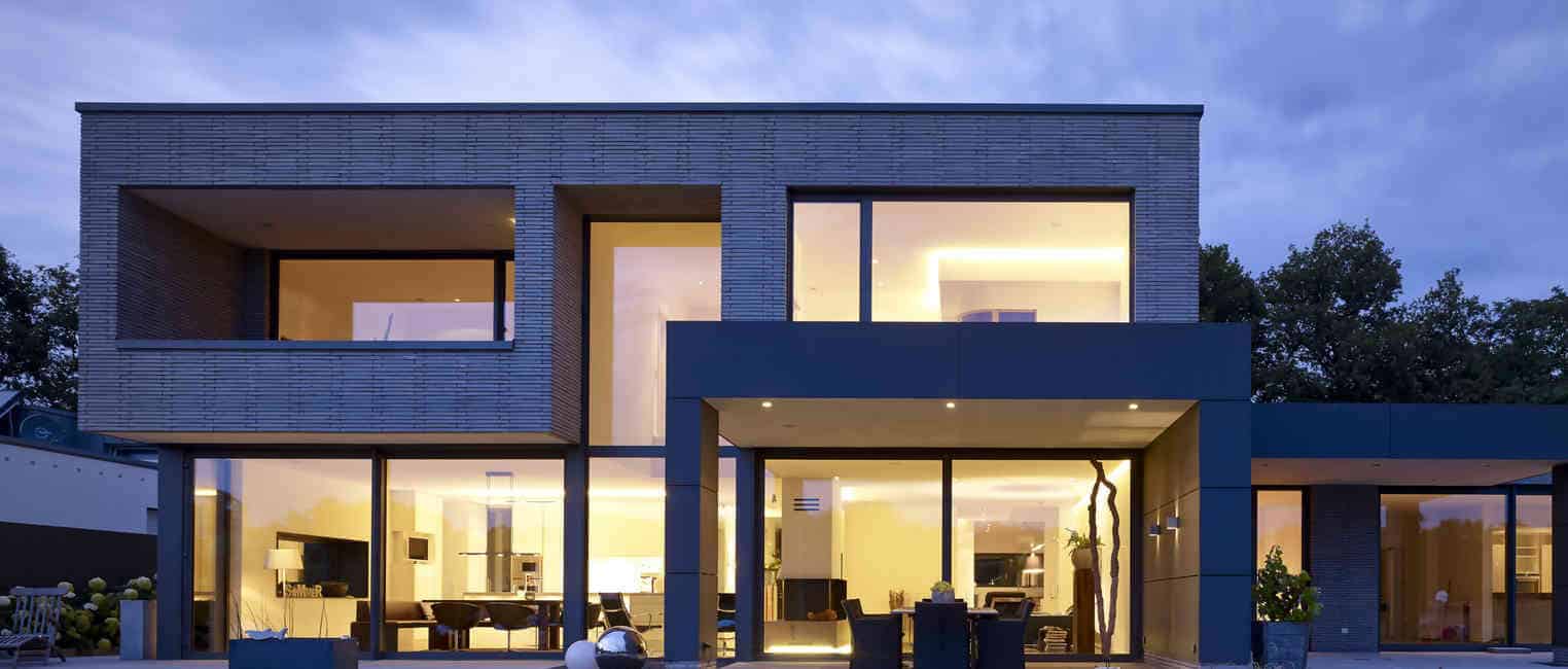 Wohnhaus mit großen Schüco Fenstern in der Abenddämmerung
