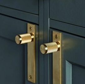 Messingknöpfe an dunkelgrünen Schranktüren
